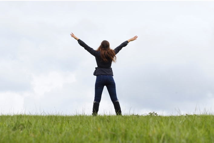 photo d'une femme les bras ouverts en V sur une colline